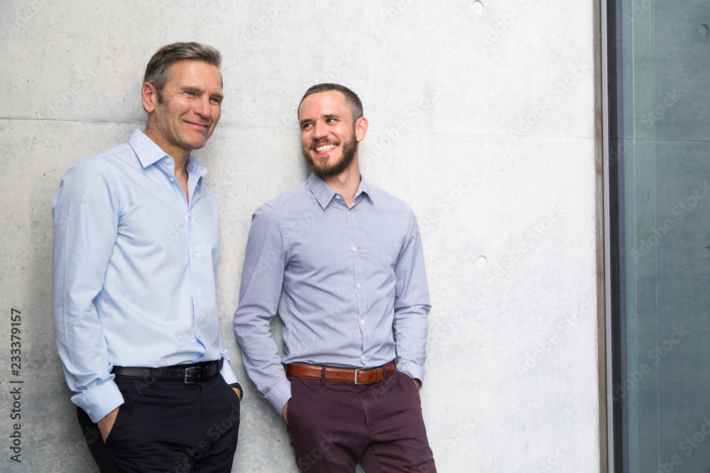 Portrait of two smiling businessmen at a wall Portrait of two smiling businessmen at a wall