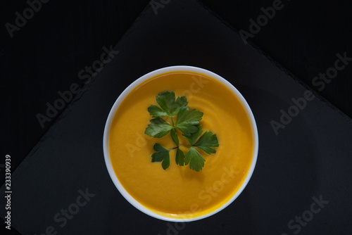 Pumpkin soup on a black wooden table.