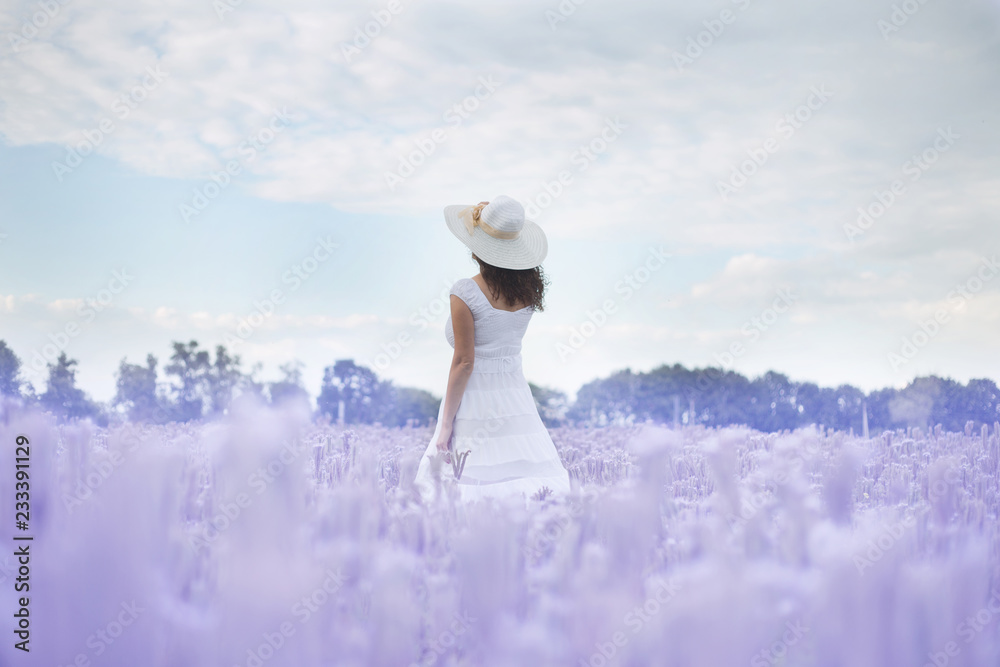 girl dancing in a white dress and hat in a field of purple flowers girl dancing in a white dress and hat in a field of purple flowers