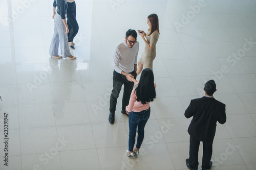 Asian office workers shake hands to greet each other in the office lobby © Nawarit