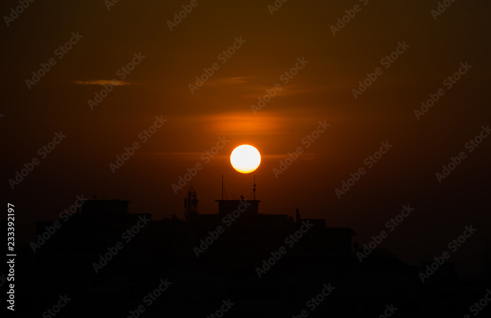 Fototapeta premium Sunrise against urban skyline