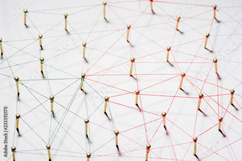 Linking entities. Network, networking, social media, internet communication abstract. A small network connected to a larger network. Web of gold wires on white wooden background. Network hub or key