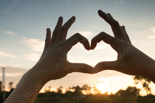 Hands in heart form love, silhouette hand make heart form with sun set