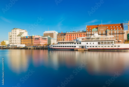Obraz na płótnie Skyline of a city reflected in water. Cityscape of Malmo with historic and modern architecture, embankment and ship, long exposure photo. Oresund region, Sweden w salonie