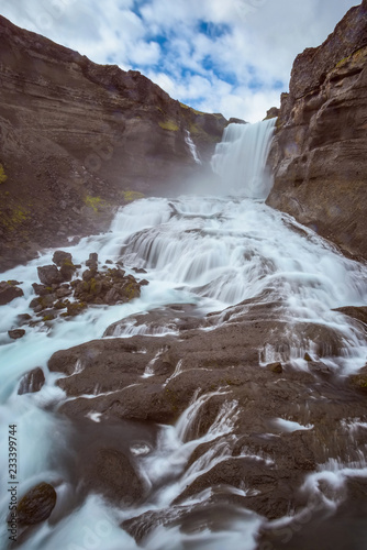 The waterfall Ofaerufoss with cloudy sky photo