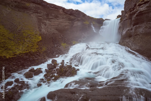 The waterfall Ofaerufoss with cloudy sky photo