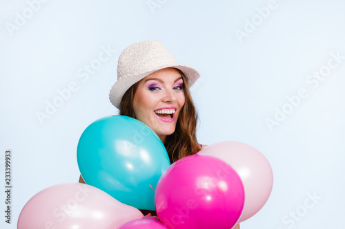 Woman playing with many colorful balloons