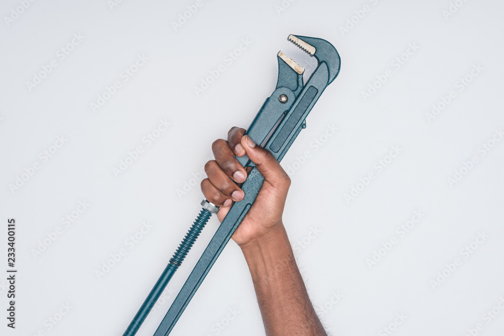cropped shot of african american man holding plumber wrench isolated on white