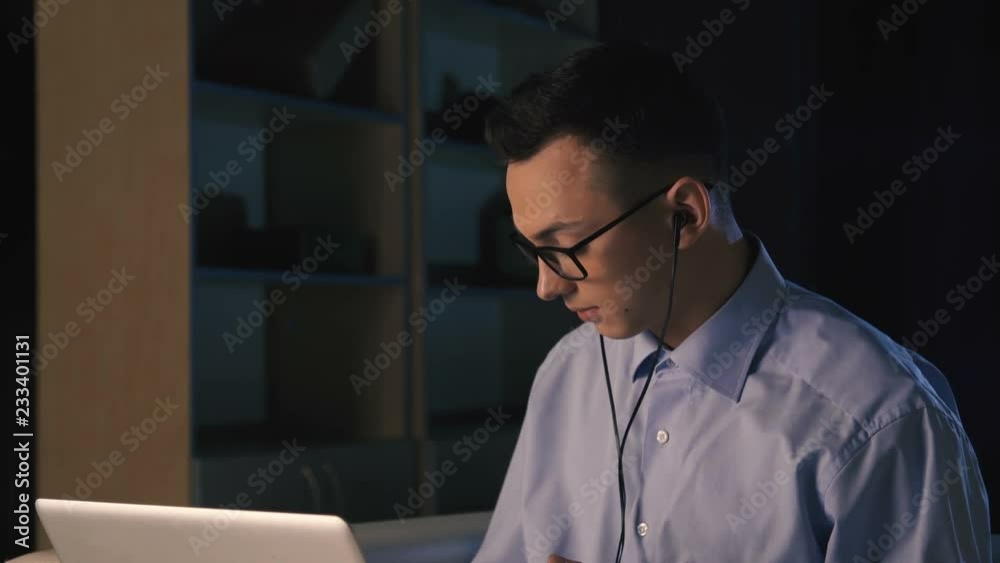 A young man talking on facetime, skype, video chat, dark background A young man talking on facetime, skype, video chat, dark background
