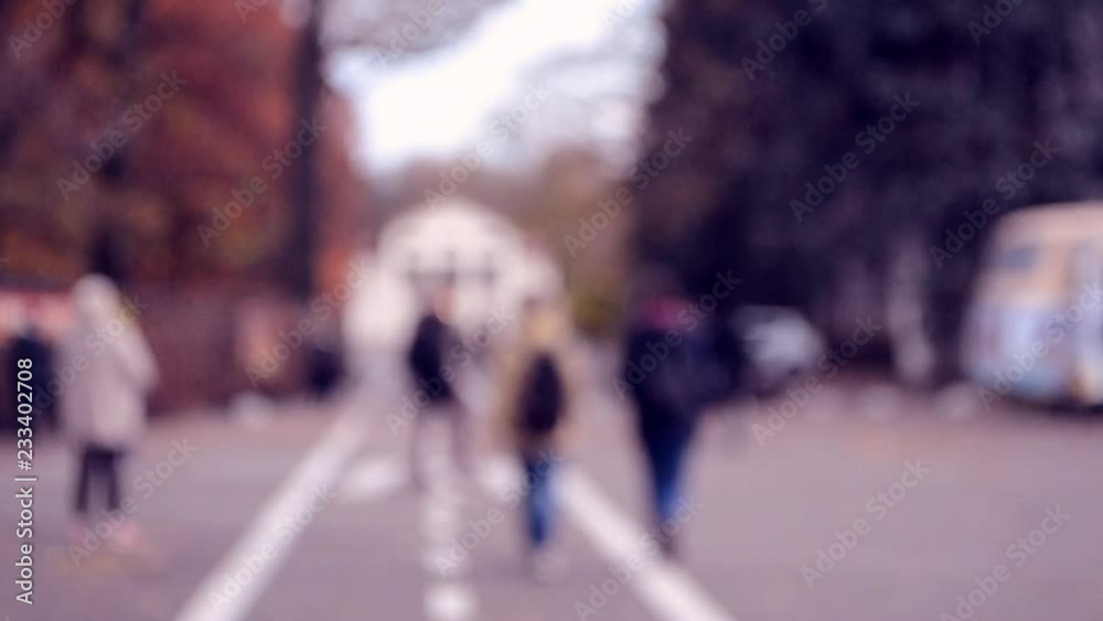 Many people walk by city square. People walking slowly relax on the town in the autumn evening. Blurred Background of city or town. Beautiful abstract urban backdrop. Many people walk by city square. People walking slowly relax on the town in the autumn evening. Blurred Background of city or town. Beautiful abstract urban backdrop.