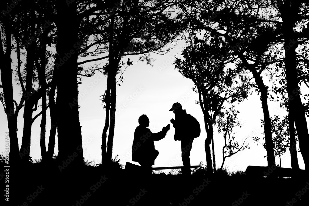 silhouette of love couple in trees border, back and white tone silhouette of love couple in trees border, back and white tone