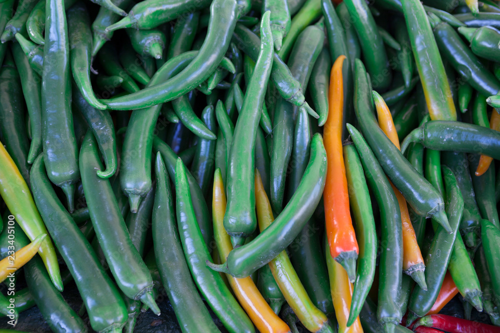 Chilli closeup, green yellow pods on the counter market. Chile pepper, Cayenne pepper, Pungent bouquet of pepper, Chinese pepper. Great photo for the sellers of vegetables.