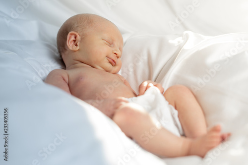 Newborn baby girl lying in a white sheet