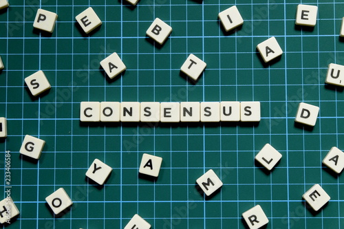 Consensus word made of square letter block on green square mat background.