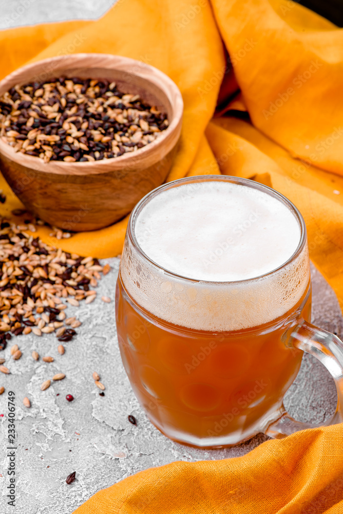 Malt grain and a glass of beer. Mixed varieties of malted grain on a gray background. close-up Malt grain and a glass of beer. Mixed varieties of malted grain on a gray background. close-up