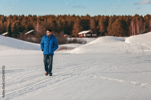young guy walking in winter in the countryside