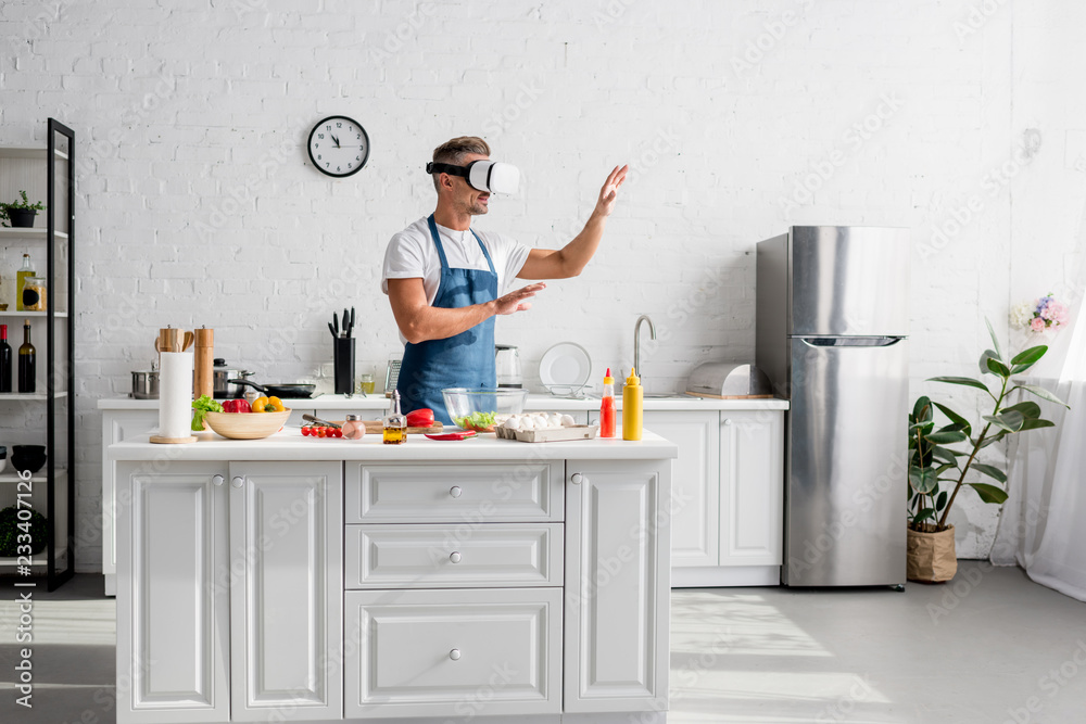 adult cooker in virtual reality headset standing at kitchen adult cooker in virtual reality headset standing at kitchen