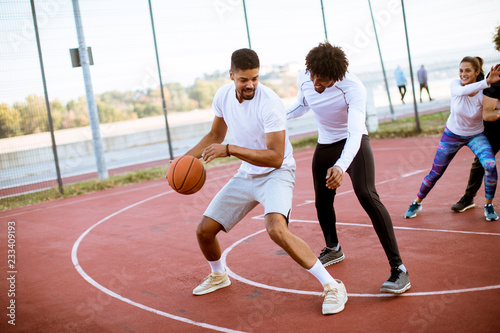 Group of multiethnic people  playing basketball on court © BGStock72