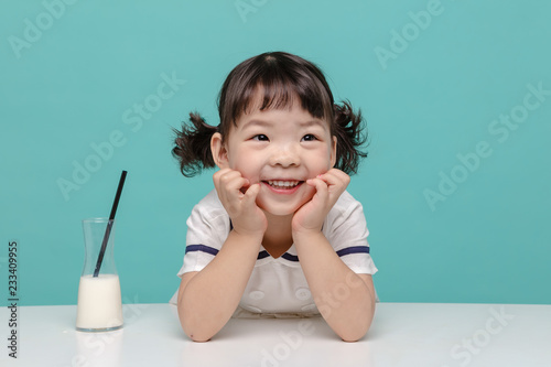 Little pretty Asian girl laughing portrait with milk and bread, healthy and happy lifestyle.