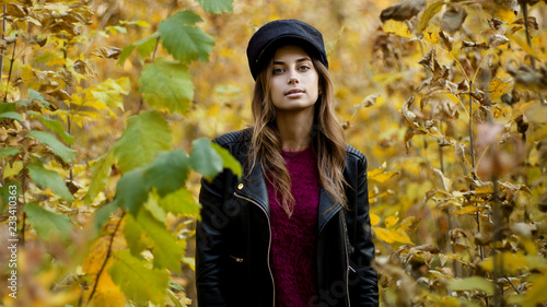 Young woman at fall, looking in camera, shallow depth of field