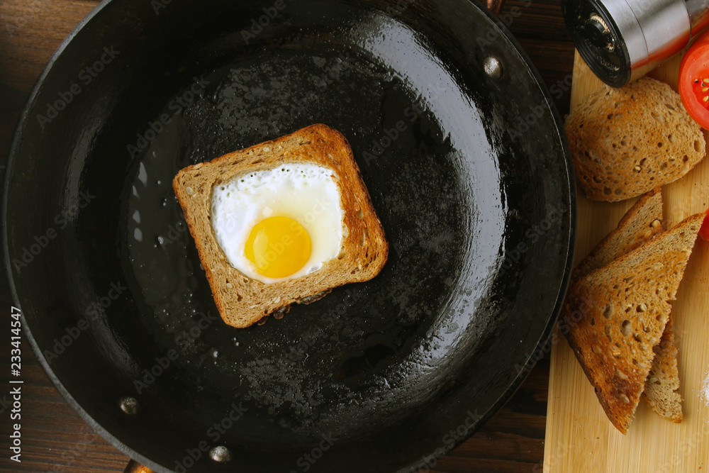 Fried eggs in bread in a pan, tomato and pepper on the table. Fried eggs in bread in a pan, tomato and pepper on the table.