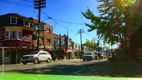 Wide, sunny, fall day time lapse of an intersection in Kensington Market, Toronto photo