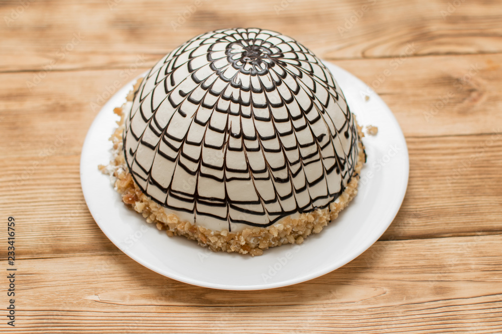 Cream cake sprinkled with spherical chocolate on a wooden background. Cream cake sprinkled with spherical chocolate on a wooden background.