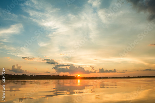 Sunset in the lake. beautiful sunset behind the clouds above the over lake landscape background. dramatic sky with cloud at sunset