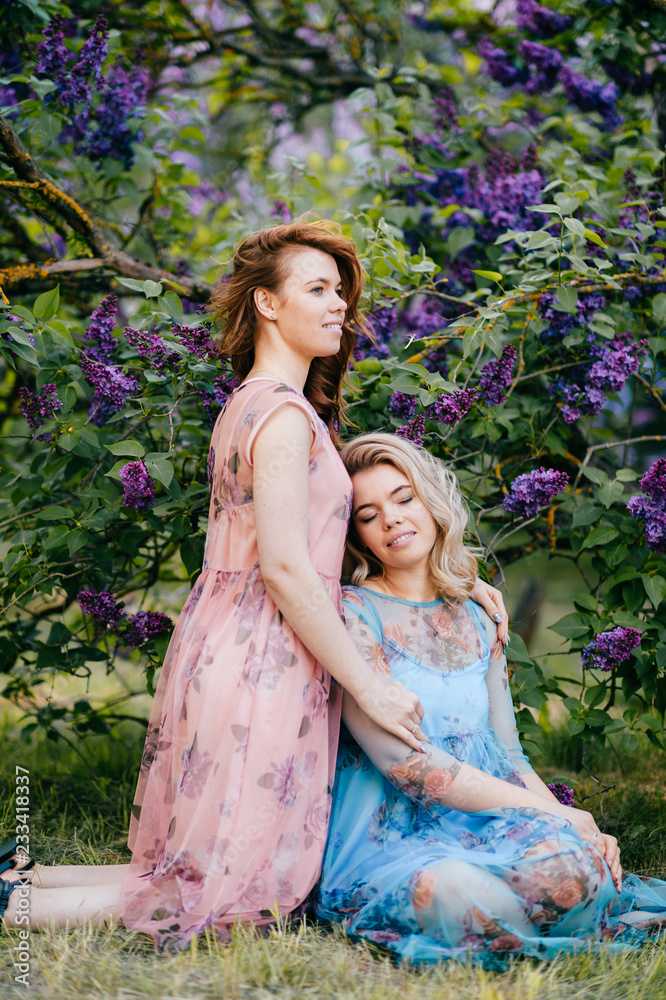 Fashion portrait of happy twin sisters. Stylish young beautiful