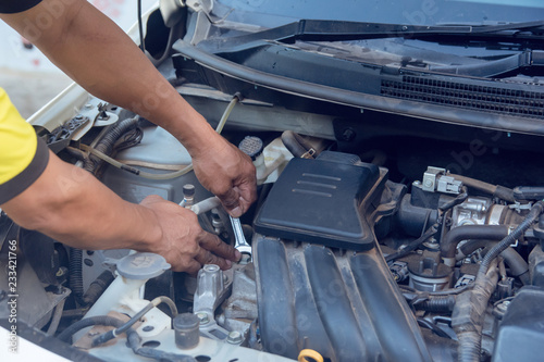 Photos Car mechanic working with wrench in garage. Repair service.