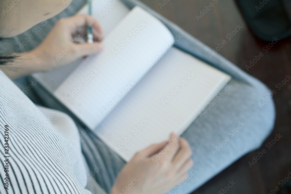 Blurred of woman is writing in note book Blurred of woman is writing in note book