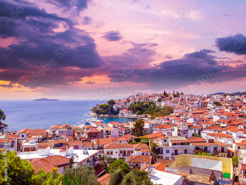 Sunset over Skiathos town on Skiathos Island, Greece. Beautiful view of the old town with boats in the harbor.