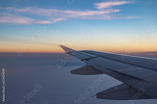 Blick aus dem Flugzeug auf den orangenen Horizont