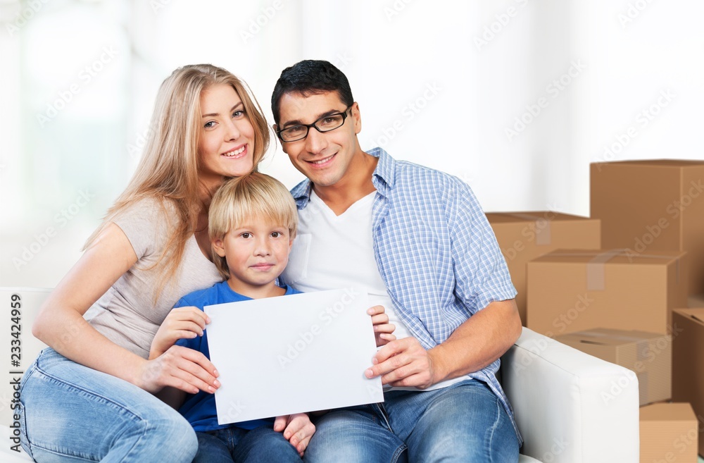 Beautiful smiling family sitting at sofa at home Beautiful smiling family sitting at sofa at home