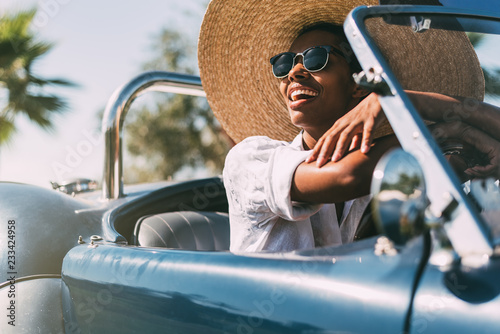 Black woman driving a vintage convertible car photo