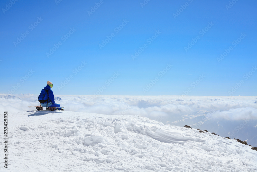 snow border sit on the top of the hill on his board  in nice sunny day. Caucasus Mountains in winter, Georgia, region Gudauri, Mount Kudebi.