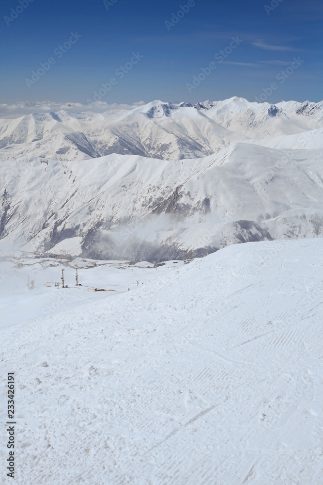 Breathtaking panorama of snowy mountains range in Ski resort Gudauri, Georgia. Panoramic view on speed riding in high peaks. Caucasus Breathtaking panorama of snowy mountains range in Ski resort Gudauri, Georgia. Panoramic view on speed riding in high peaks. Caucasus