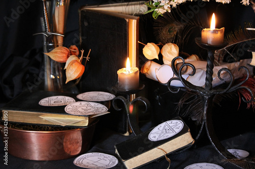 Antique Magic Book. Witchcraft Peacock feathers and candle background. Black candle Magic Ritual.