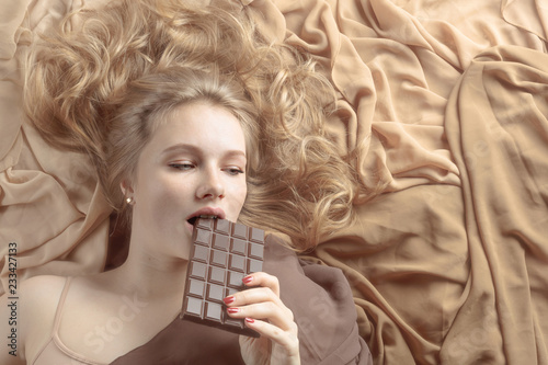 Happy young beautiful woman eating chocolate.