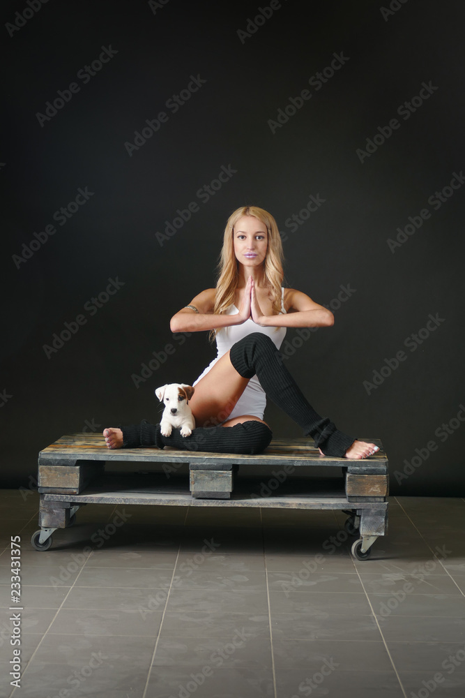 Young woman with puppy in yoga pose