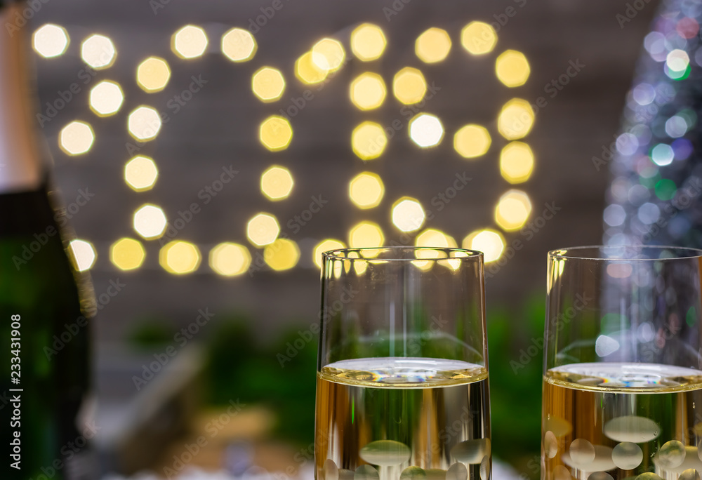 Moody new year decoration concept-glass of champagne on blurred new year background.