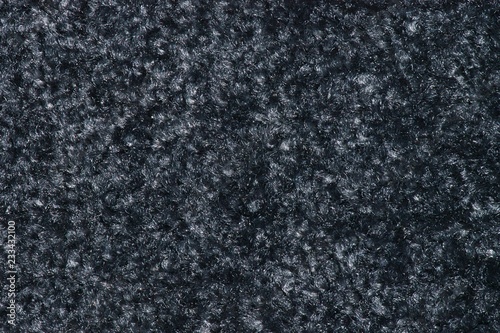 Texture of a swatch of thick smoky black floor mat with light-colored gray flecks in it.