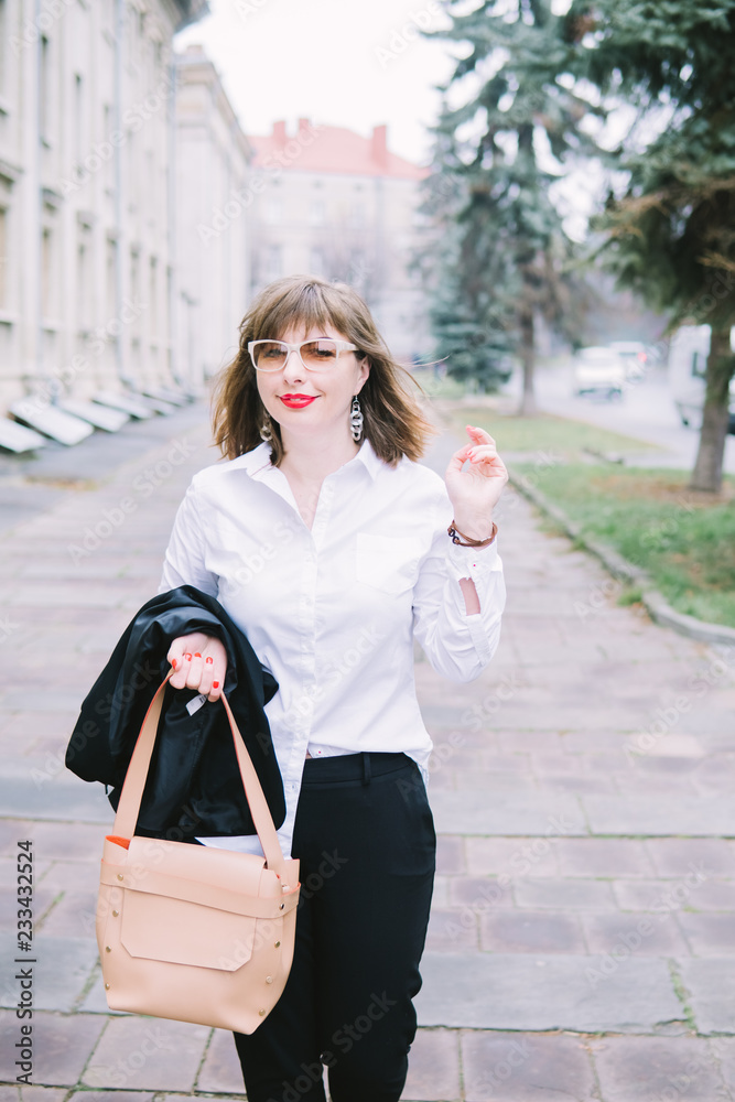 Business Women Style. Woman Going To Work Walking Downstairs. Portrait Of Beautiful Smiling Female In Stylish Office Clothes Going Old Town. Business Women Style. Woman Going To Work Walking Downstairs. Portrait Of Beautiful Smiling Female In Stylish Office Clothes Going Old Town.