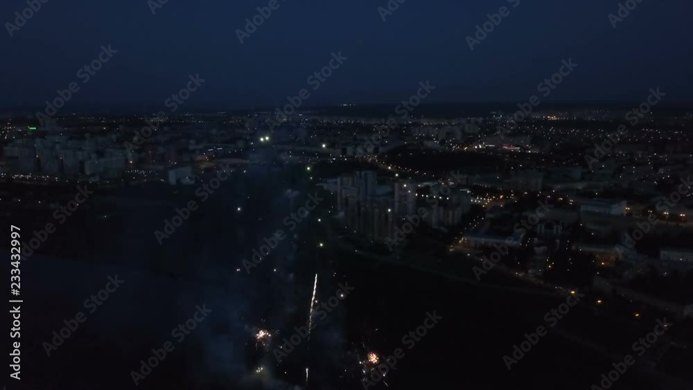 Amazing scene of fireworks above the urban illumination shine city at event for xmas or birthday party or wedding. Different colors of firecracker moving up, burning and bursting in the evening sky Amazing scene of fireworks above the urban illumination shine city at event for xmas or birthday party or wedding. Different colors of firecracker moving up, burning and bursting in the evening sky