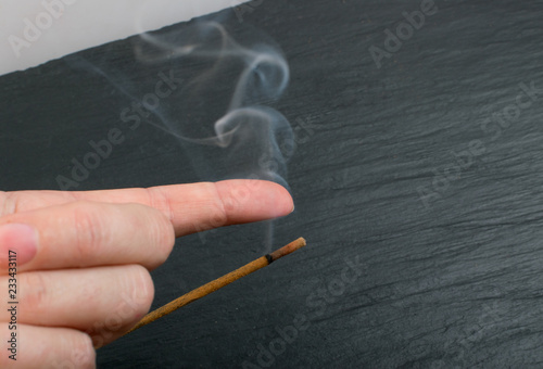 Burning incense aroma sticks with smoke on black background photo