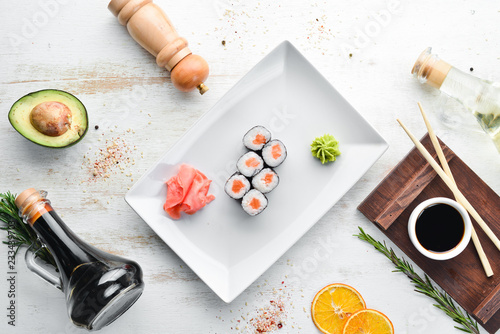 Sushi roll maki with salmon. Japanese cuisine. Top view. On a white wooden background.