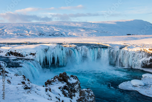 Frozen Godafoss waterfall on cold winters day at dawn, Northern Iceland