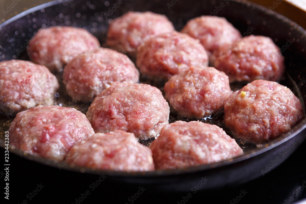 Fried meat patties are cooked in a pan in the oil in the kitchen with steam
