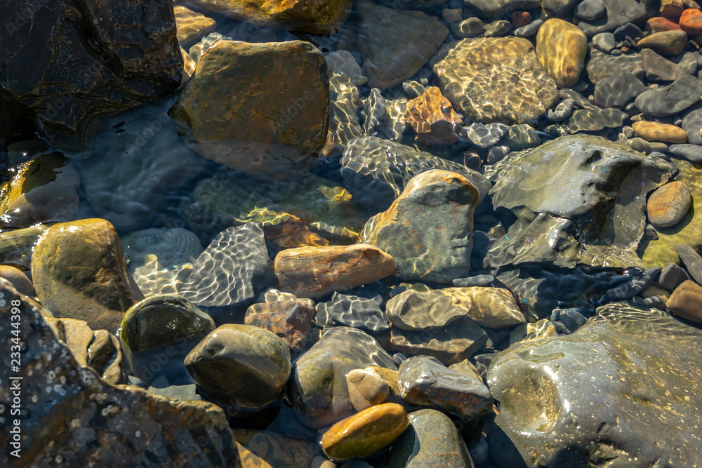 Sea stones and rocks of different sizes and texsture of black, gray and brown under the water on the Black Sea coast as nature bacground. Excellent concept for any design Sea stones and rocks of different sizes and texsture of black, gray and brown under the water on the Black Sea coast as nature bacground. Excellent concept for any design