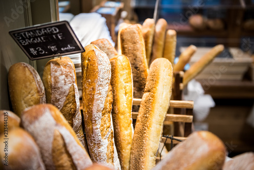 Closeup of fresh golden standard baked baguette loaves in bakery basket photo